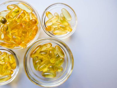 Cam tabakta balık yağı kapsülleri. Beyaz arka planda bir sürü Omega 3 vitamini var. Yakın çekim, üst görüş, yüksek çözünürlüklü ürün. Vücutta metabolizma. Kalsiyum kütlesi. Kilo vermenin hızlı bir yolu