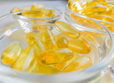 Cam tabakta balık yağı kapsülleri. Beyaz arka planda bir sürü Omega 3 vitamini var. Yakın çekim, üst görüş, yüksek çözünürlüklü ürün. Vücutta metabolizma. Kalsiyum kütlesi. Kilo vermenin hızlı bir yolu