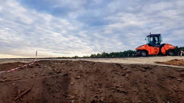 Ucraina, Kiev - 1 ottobre 2019: Rullo stradale, trattore e attrezzature per l'edilizia stanno lavorando a un nuovo cantiere stradale. La strada è chiusa per la riparazione stradale, estensione del percorso, riparazione buche — Foto Stock