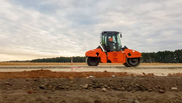 Ucraina, Kiev - 1 ottobre 2019: Rullo stradale, trattore e attrezzature per l'edilizia stanno lavorando a un nuovo cantiere stradale. La strada è chiusa per la riparazione stradale, estensione del percorso, riparazione buche — Foto Stock