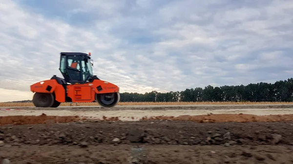 Ucraina, Kiev - 1 ottobre 2019: Rullo stradale, trattore e attrezzature per l'edilizia stanno lavorando a un nuovo cantiere stradale. La strada è chiusa per la riparazione stradale, estensione del percorso, riparazione buche — Foto Stock