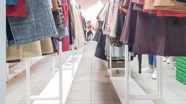 Kleidungsstücke hängen in den Regalen eines Designergeschäfts. Bekleidungsgeschäft. Kleidergang in einem Supermarkt. — Stockfoto
