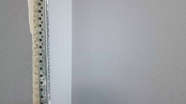 Duvarda köşe macunu var. Duvarı kokutmak için köşe, alçıdan duvarın yıkılmış kısmı. Kaliteli bir tamir değil. Kopyalama alanı olan arkaplan İnşaatta bitirme işi