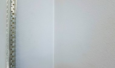 Duvarda köşe macunu var. Duvarı kokutmak için köşe, alçıdan duvarın yıkılmış kısmı. Kaliteli bir tamir değil. Kopyalama alanı olan arkaplan İnşaatta bitirme işi