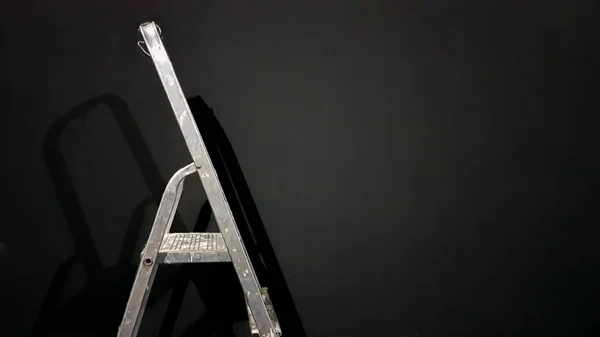 Escada de passo de ferro contra uma parede cinza. A preparar-se para reparações em casa. Alumínio velho e sujo numa sala vazia, sombra. Branco cinza estuque parede de concreto cópia espaço fundo com escadaria. Renderização 3D — Fotografia de Stock