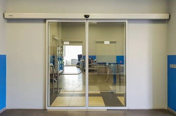 Empty sliding glass front door at the airport. Glass doors in the office. Glass entrance. Entrance to administration building equipped with automatic door — Stock Photo, Image