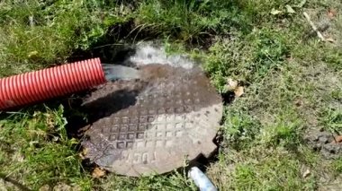 Kırmızı kıvrımlı bir borudan akan su kanalizasyona akıyor. Su akıyor. Yağmur borulardan akar ve aşağı düşer. Atık su harici kanalizasyona akar. Pompayla su pompalamak