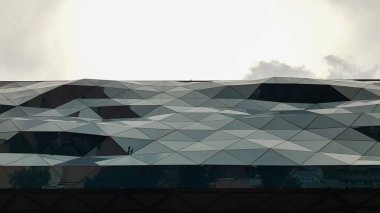 Kavisli cam bir binanın ön cephesi. Modern mimari. Alışılmadık bir alışveriş merkezi tasarımı.