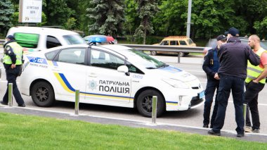 Ukrayna, Kiev - 2 Haziran 2020. Ukrayna 'daki Kiev yollarında polis devriye arabaları güvenliği sağlıyor. Bir erkek polis yolda arabasının yanında duruyor..