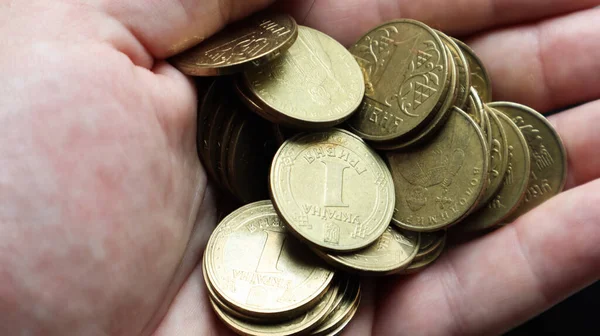Erkek elinin avucunda 1 hryvnia değerinde Ukrayna metal sikkeleri. Ellerinde bir avuç dolusu bozuk para. Emeklilik, tasarruf ve zenginlik kavramı, kredi ve ipotek, yoksulluk