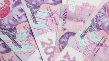 200 Hryvnia değerindeki banknotlar yavaşça döner. Ukrayna ulusal para birimi. Nakit kağıt paraların yakın plan çekimleri. Reklamlar