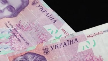 200 Hryvnianın nominal değeri masaya düşüyor ve yavaşça dönüyor. Ukrayna ulusal para birimi. Nakit kağıt paraların yakın plan çekimleri. Reklamlar