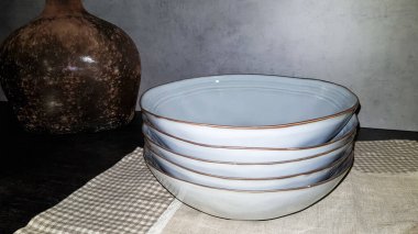 Büyük cam vazolar, modern bir mutfağın içinde elmalar ve tabaklarla dolu bir sepet. Tasarımda ahşap ve beton kombinasyonu. Modern tarz yemek mutfağı..