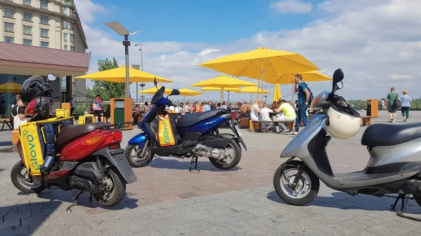 Ukrayna, Kiev - 29 Ağustos 2020. McDonalds yakınlarında Glovo logosu olan bir sürü park etmiş motosiklet var. Mobil uygulamayla sipariş edilen malları getiren kurye servisi. Yayın fotoğrafçılığı