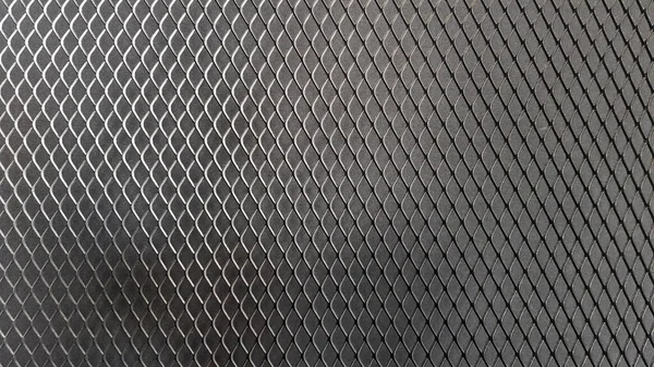 Metal mesh seamless pattern. Black metal mesh texture on a black background. Bulletin board for text and message design. Rhombus shape.
