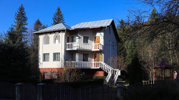 Вид на живописные деревенские дома и коттеджи на фоне гор. Город Яремче среди Карпат осенью днем. Украина, Яремче - 20 ноября 2019.