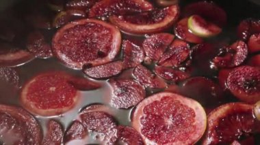 Dışarıda ateşte pişirilmiş sıcak şarap. Kapatın. Kış içeceğindeki vitaminler. Sokak lokantası. Sıcak sıcak şarap. Sıcak şarap kazanlarının üzerinde yoğun bir buhar. Yavaş çekim videosu.