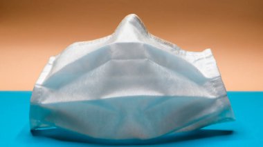 Ağzını ve burnunu kapamak için plastik pedlerle tek kullanımlık bir yüz maskesi. Bakterilerden, sağlık hizmetlerinden ve tıptan korunma kavramı. COVID-19. Tehlikeli bir virüs..
