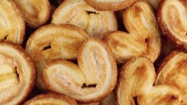 Kalp şeklinde taze avuç içi puf böreklerini döndürüyorum. Fil kulaklı Fransız bisküvileri. Yukarıdan bak. Yakın plan.