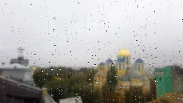 在多云的天气里 潮湿的窗户上挂着秋天的背景的雨滴 雨中从窗户往外看 雨中玻璃窗上的水滴 背景模糊 — 图库照片