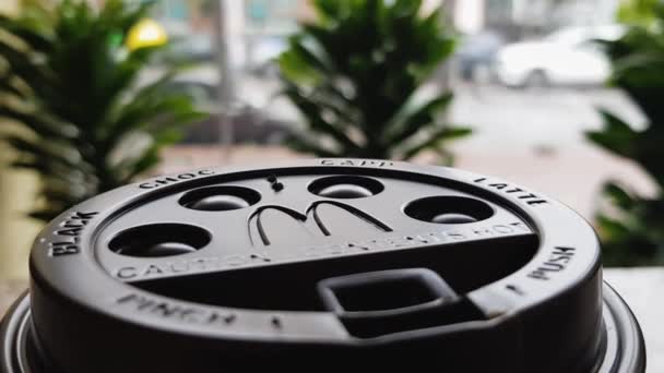 맥도날드의 패스트 레스토랑에 커피의 뚜껑을 배경이 해졌다 플라스틱뜨거운 뚜껑을 덮는다 — 비디오