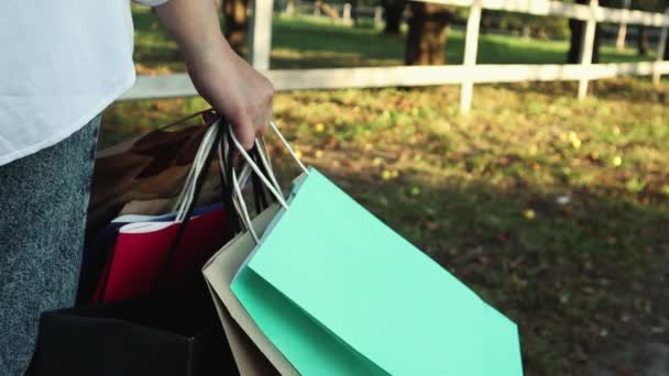 Close Van Hand Van Een Vrouwelijke Shopper Met Kleurrijke Papieren — Stockvideo