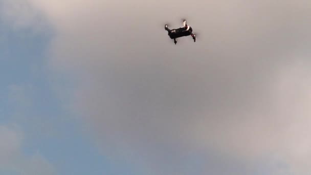 曇り空を背景に空中からカメラでドローンを着陸させる クワッドコプターは発射台に戻り 発射場に戻る 高速回転ドローンプロペラ — ストック動画