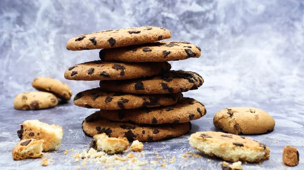 American chocolate chip cookies stacked on top of each other on a beautiful gray marble background. Traditional rounded crunchy dough with chocolate chips. Bakery. Delicious dessert, pastries