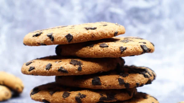 American chocolate chip cookies stacked on top of each other on a beautiful gray marble background. Traditional rounded crunchy dough with chocolate chips. Bakery. Delicious dessert, pastries