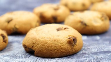 Gri mermer mutfak tezgahında taze pişmiş çikolatalı kurabiyeler. Geleneksel Amerikan tatlısı, nefis ev yapımı tatlı. Mutfak geçmişi. Seçici odak.