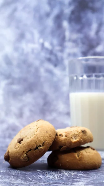 American gluten free chocolate chip cookies with glass glass of vegetable milk on gray background. Chocolate chip cookies. Sweet pastries, dessert. Culinary background. Vertical photography