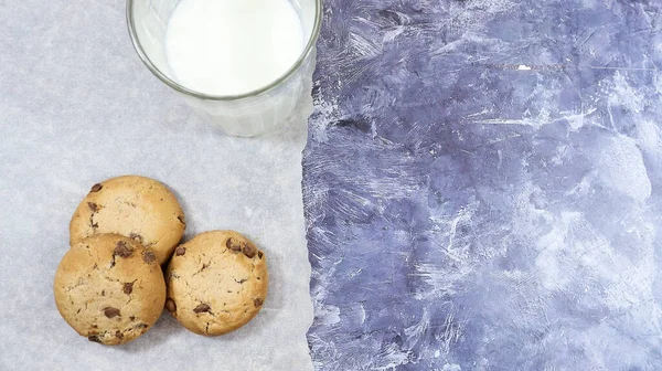 American gluten free chocolate chip cookies with glass glass of vegetable milk on gray background. Chocolate chip cookies. Sweet pastries, dessert. Culinary background. Copy space. Flat lay