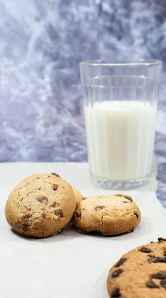 American gluten free chocolate chip cookies with glass glass of vegetable milk on gray background. Chocolate chip cookies. Sweet pastries, dessert. Culinary background. Vertical photography