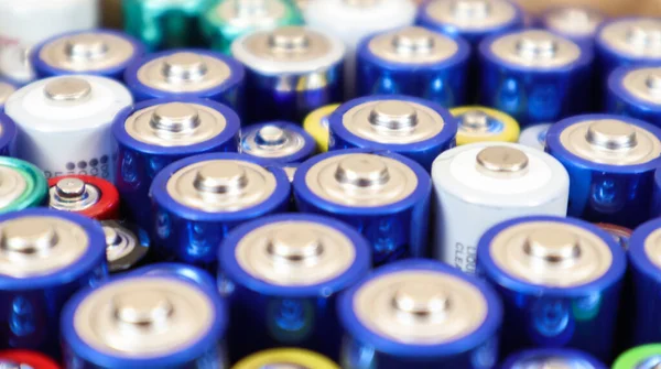 Background view of AAA AA batteries and rechargeable batteries. Choice of batteries. Energy supply and recycling concept. Textures of electrical elements packed close to each other