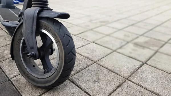 Das Vorderrad Eines Elektrorollers Auf Einer Stadtstraße Vor Dem Hintergrund — Stockfoto