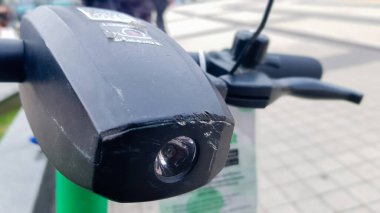 Elektrikli scooter 'ın direksiyonunu el feneriyle kapat. Dışarıda elektrikli scooter kiralama şirketi var. Binicilik sorunu. Ekolojik ulaşım kavramı
