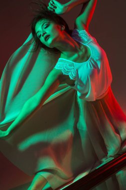 Kulüpte çekici dans eden kız, neon ışık, hareket efektleri. Siyah arka plan, uzun pozlama