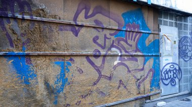                  Eski graffity duvar ve çelik kapı. Renklerde endüstriyel duvar mavi mor.              