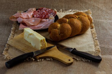 Sosis aperatifli örgü ve masada sade masa örtüsü ve bıçaklı peynir.