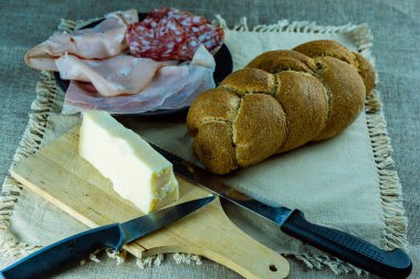 Sosis aperatifli örgü ve masada sade masa örtüsü ve bıçaklı peynir.