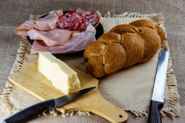 Sosis aperatifli örgü ve masada sade masa örtüsü ve bıçaklı peynir.