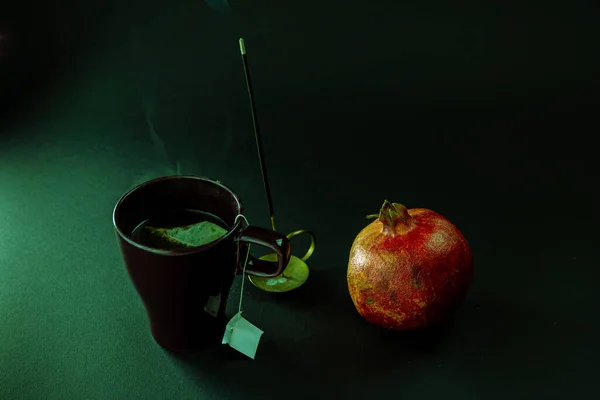 有一杯茶和黑背景的天然石榴的静谧生活 — 图库照片