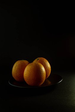 Siyah zemin üzerinde taze mevsimlik portakallar