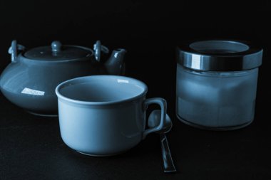 Bir fincan çay, geleneksel çaydanlık ve şeker kasesi.