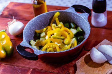 Bahçeden taze sebzelerle, ahşap masada soğan, kabak ve sarı biberle dolu bir hayat..