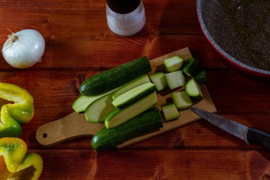 Bahçeden taze sebzelerle, ahşap masada soğan, kabak ve sarı biberle dolu bir hayat..