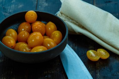 Taze kırmızı, yeşil ve sarı domateslerle dolu bir hayat. Tahta masa ve mutfak bıçağının bahçesinden yeni toplanmış.
