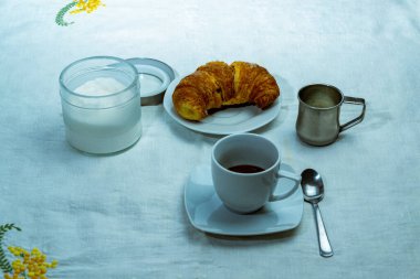 Bir fincan kahve ve beyaz masa örtüsünün üstünde çikolatalı kek ile hayat