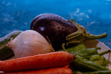 Bahçeden taze sebzelerle, ahşap masada soğan ve kabakla dolu bir hayat. Domates, patlıcan, fasulye ve yeşil biber..