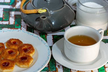 Kırsal arka planda şekerli ve kurabiyeli bir fincan siyah çayla hayat